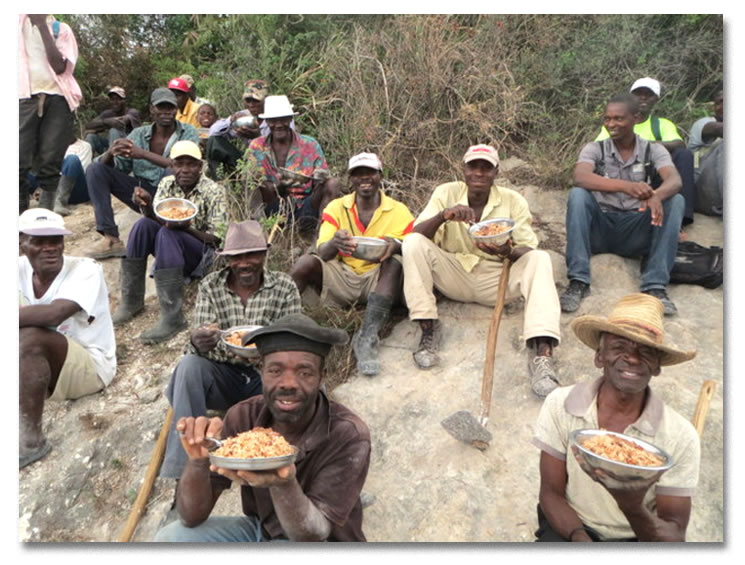 Men eating on the side of mountain