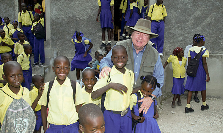 Missionary Bobby Burnette feeding and helping children in Haiti.