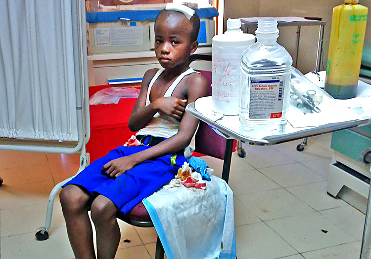 Injured child in well-equipped emergency room.