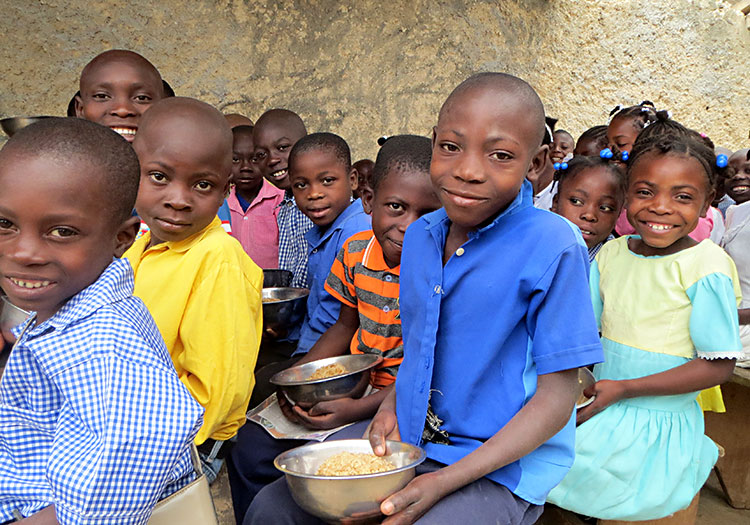 Happy children being fed a meal each day