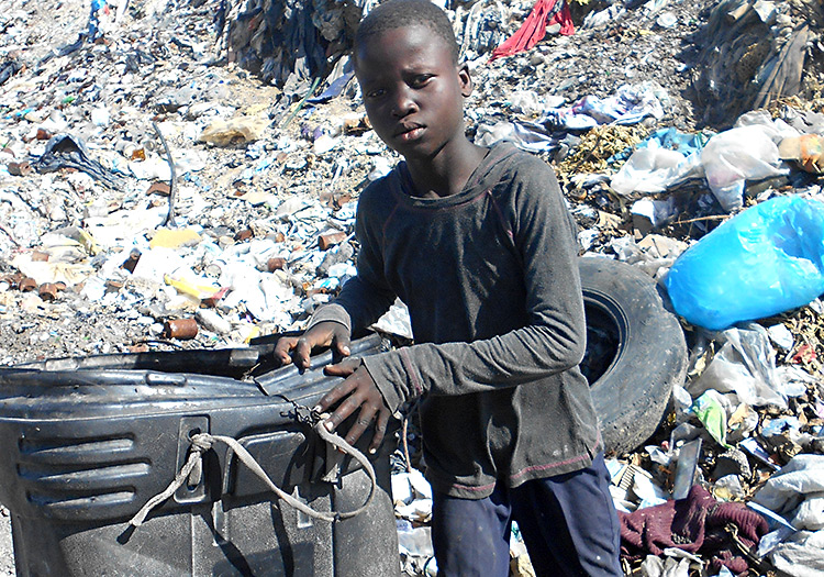 Young boy scavenging for food in the dump.