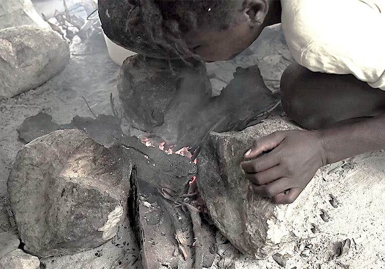 Haitian child starting a fire.