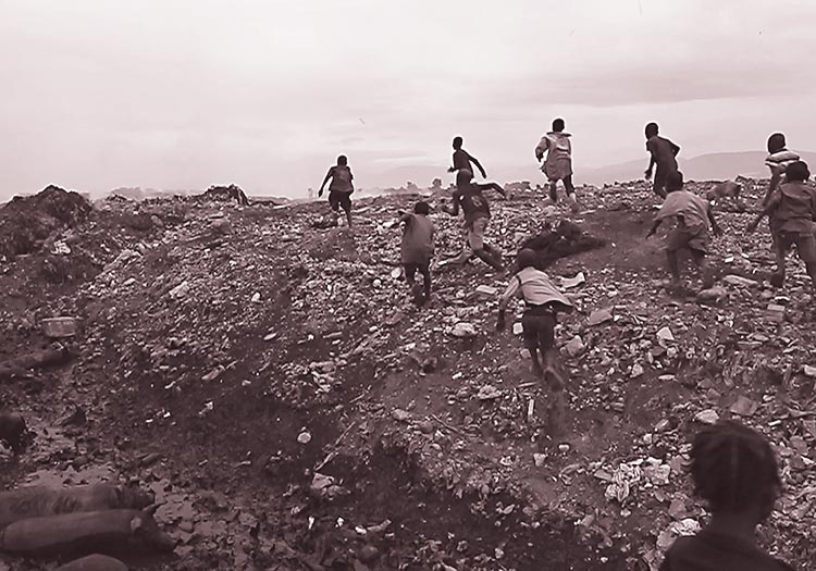 Haitian children running through the garbage at Truttier.