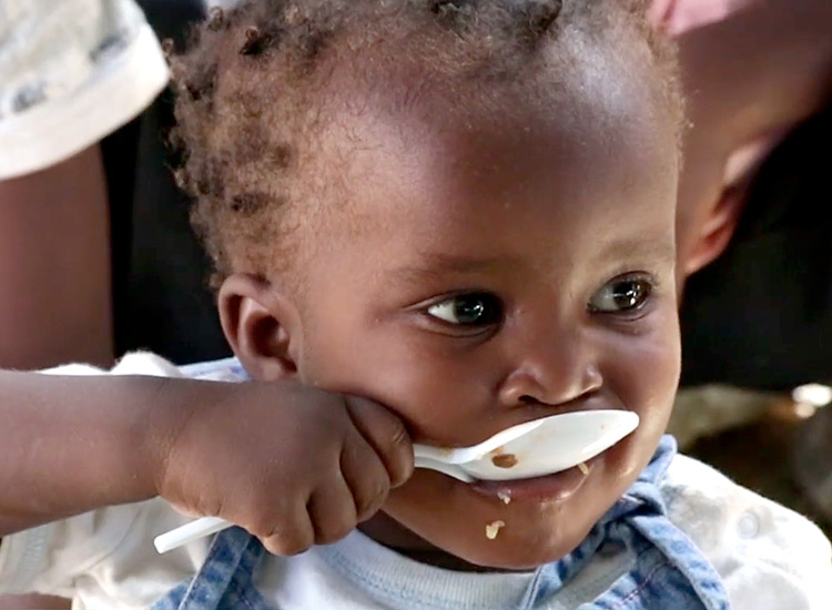 Haitian child eating manna pack food.