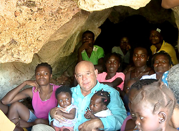 Joel Trimble in cave with Jaitian families