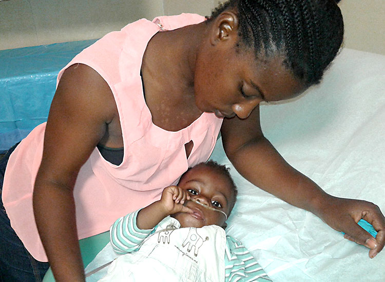 Mother with sick child at Jesus Healing Center.