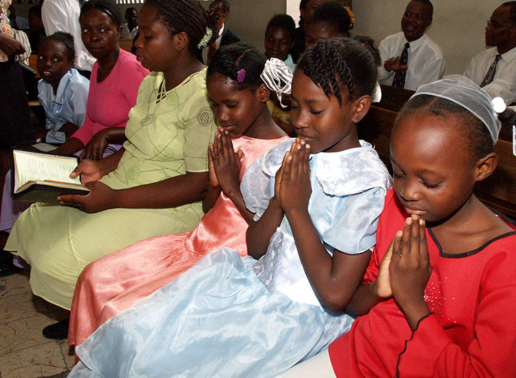 Haitian children praying in church.
