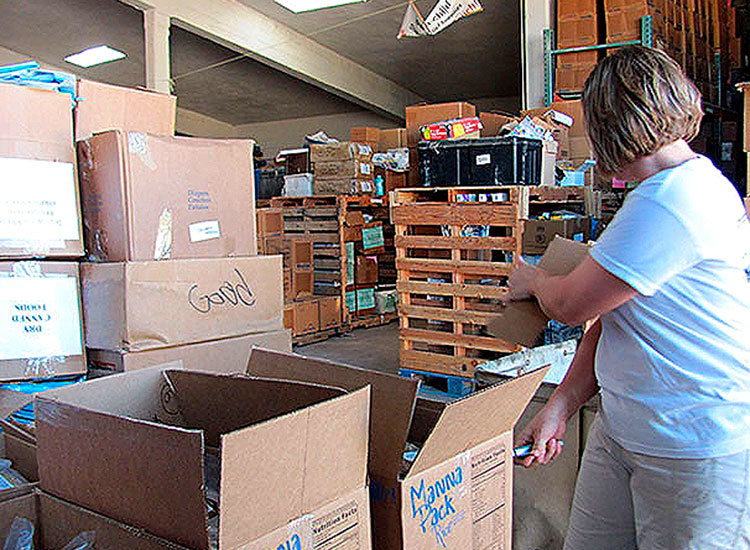 Volunteers assemble food packs at several of the company's packing locations.