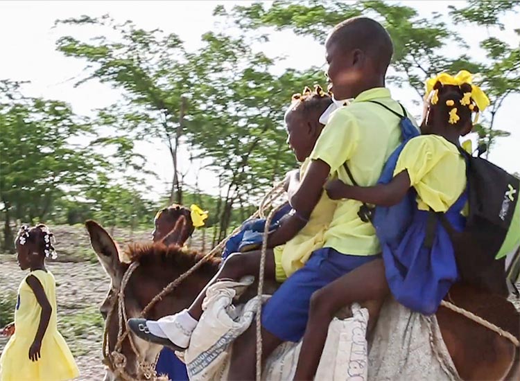 Young children travel by donkey to reach their temporary school. 