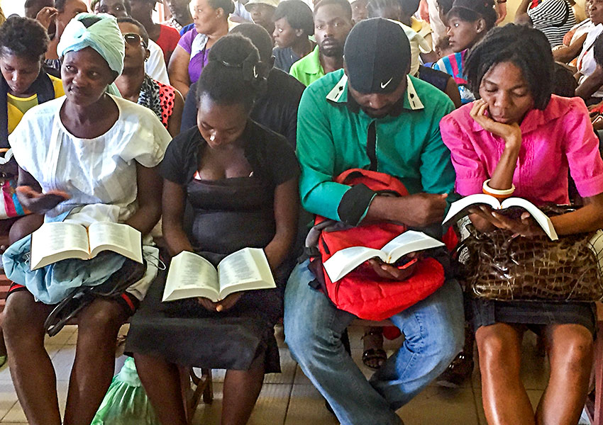 Haitians reading their new Creole Bibles at the Jesus Healing Center.