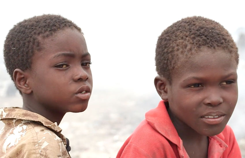 These two little boys are brothers who lived in the Truttier garbage dump among the garbage, flies, and pigs.