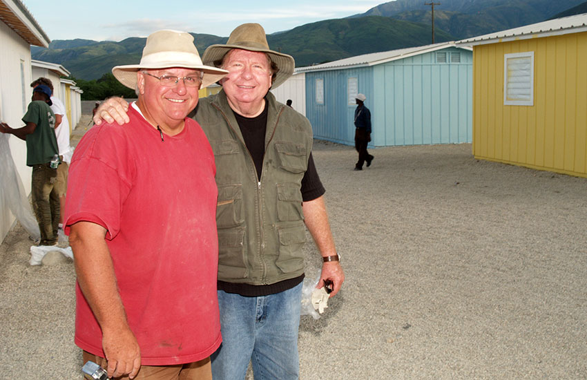 Mark Ostrander and Bobby watch as construction on Miracle Village progresses.