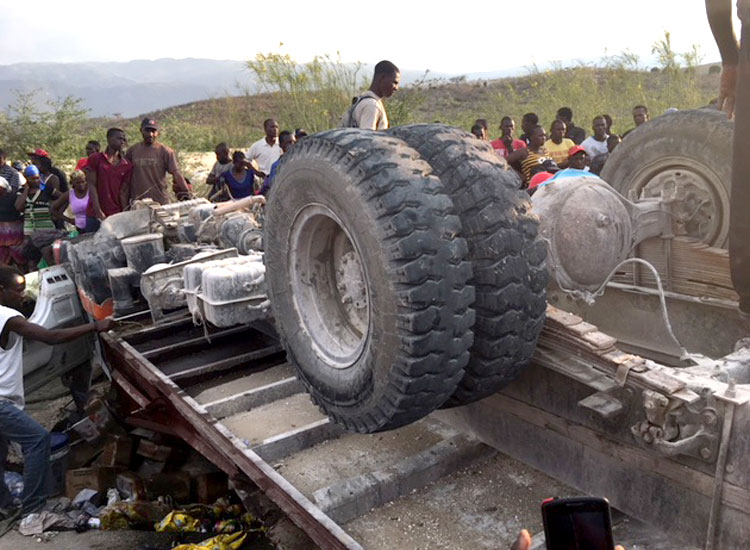 A horrible accident involving a huge truck that was filled inside and on top with poor Haitian vendors.