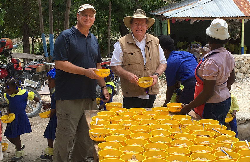 Mark Crea, CEO of Feed My Starving Children, and Bobby dish out some food.