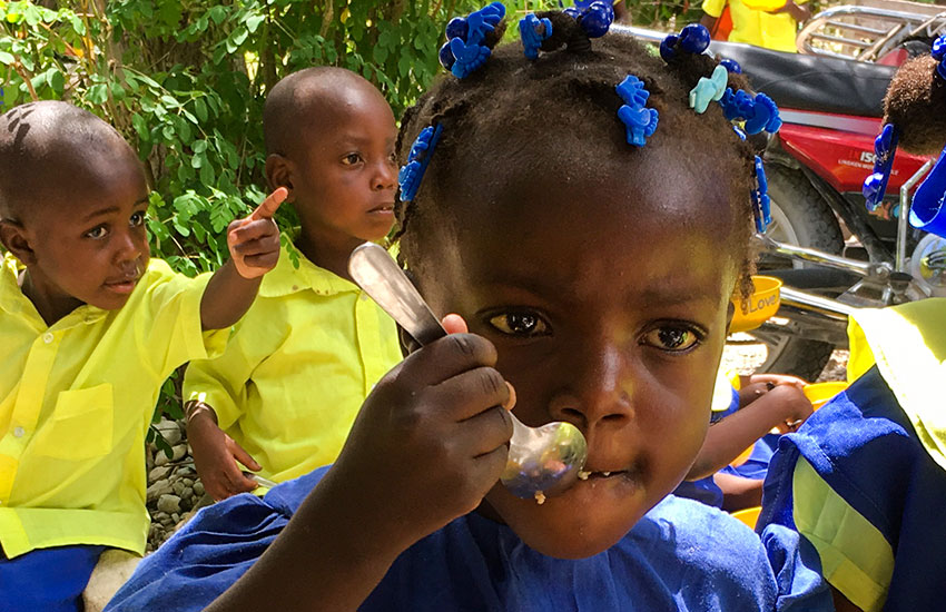 Schoolchildren eating at the Love A Child Lastik School.