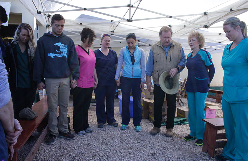  Our great volunteer team members who came to Haiti pray before the Mobile Medical Clinic.