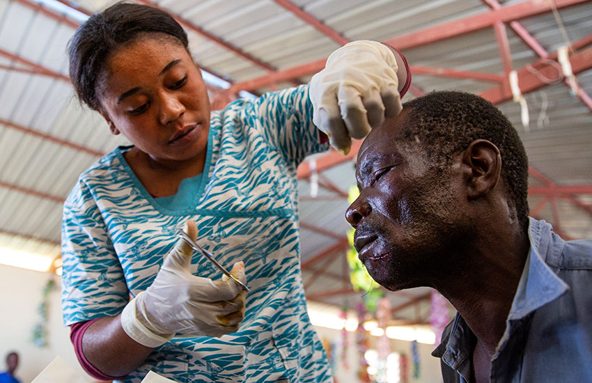 Jovanie stitches up a patient's wound.