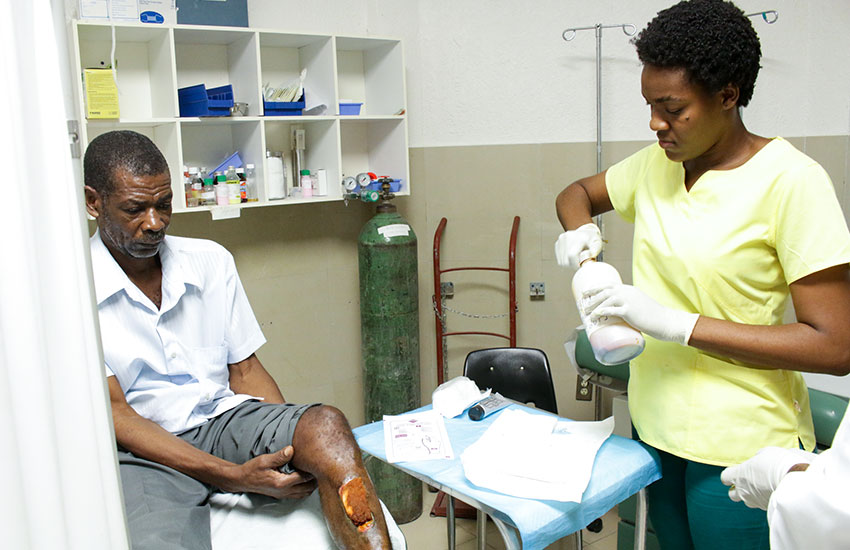 Roselyne attends to a patient at our Jesus Healing Center.