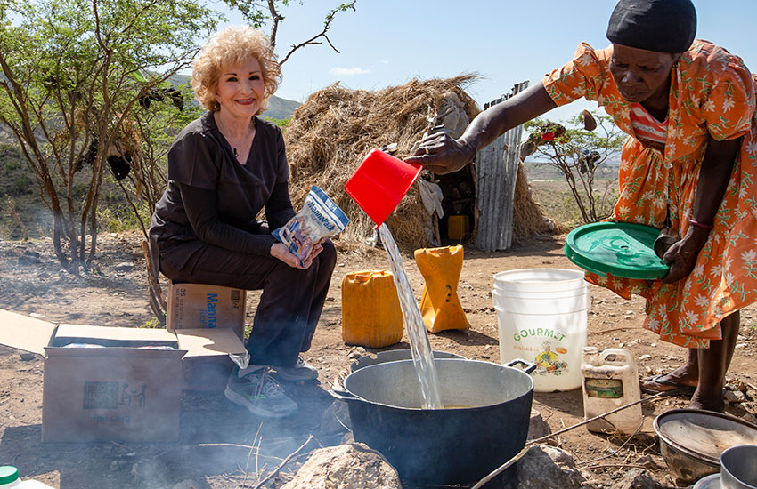 We brought food to them, and we had to sit on boxes and buckets to cook.