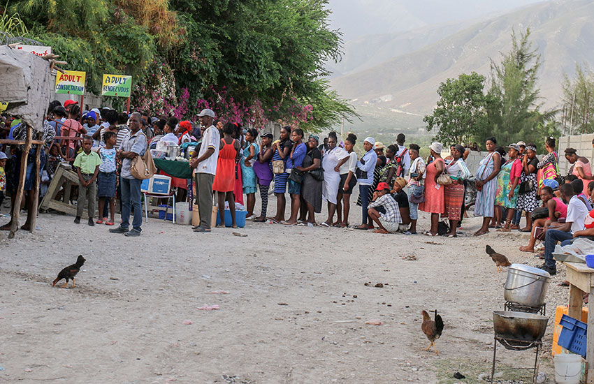 A waiting line forms outside the gate as hundreds of people gather to get first in line to enter the clinic.